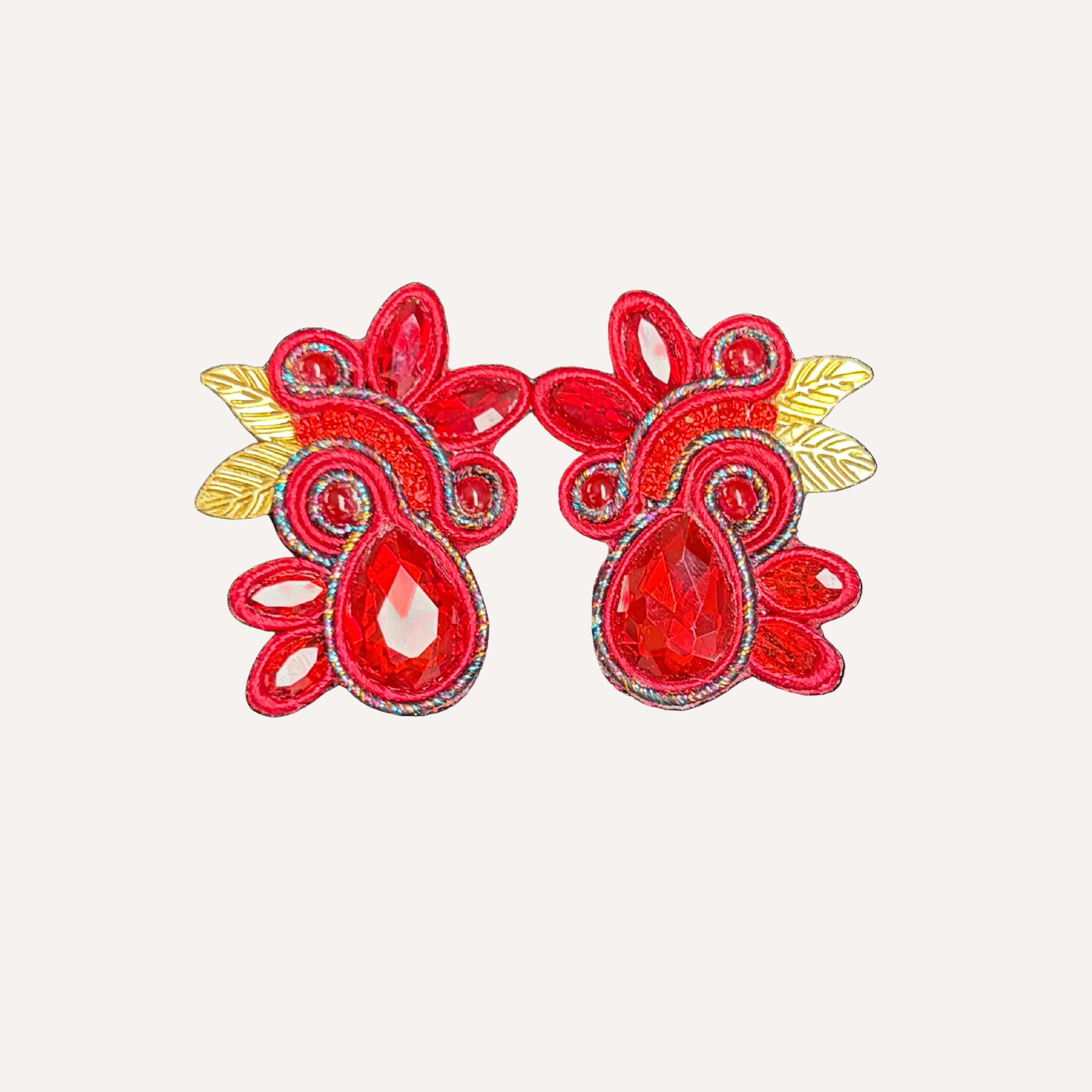 Red embroidered earrings with gold accents on a white background