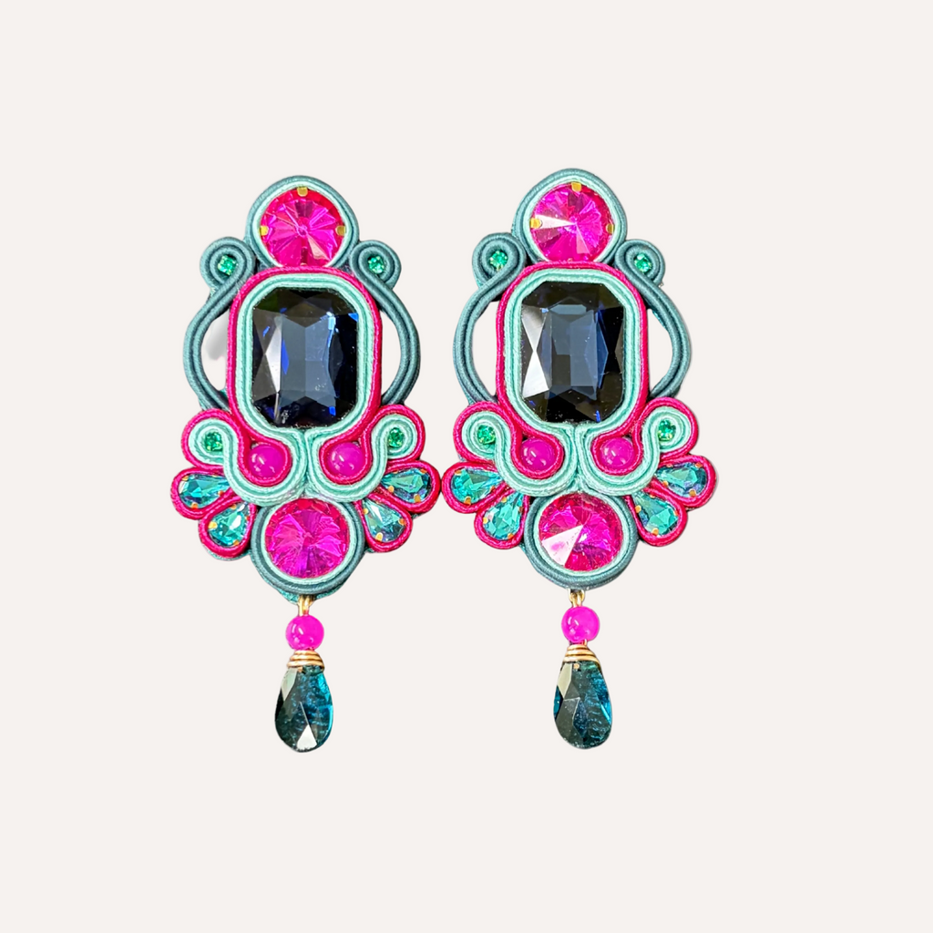 Colorful earrings with pink and blue accents on a white background